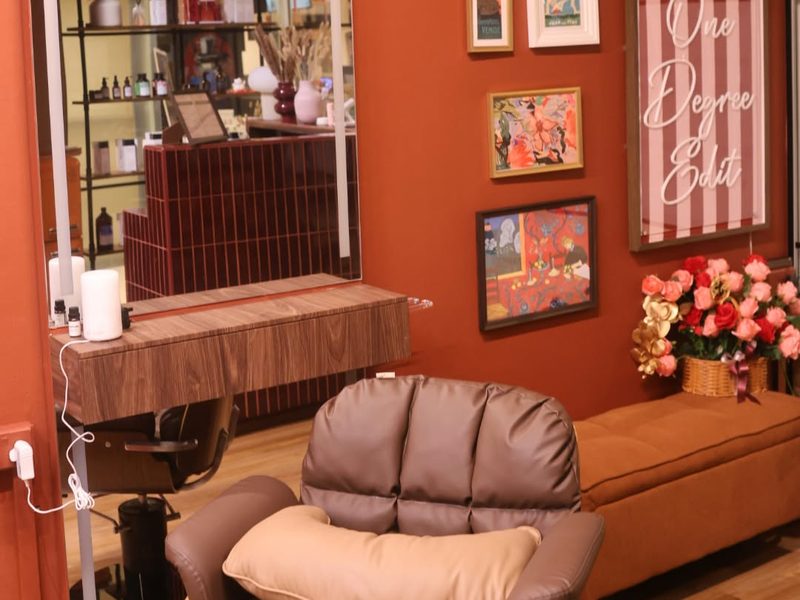 Brown leather styling chair in front of an arched mirror and gallery wall at One Degree Edit, Havelock 2