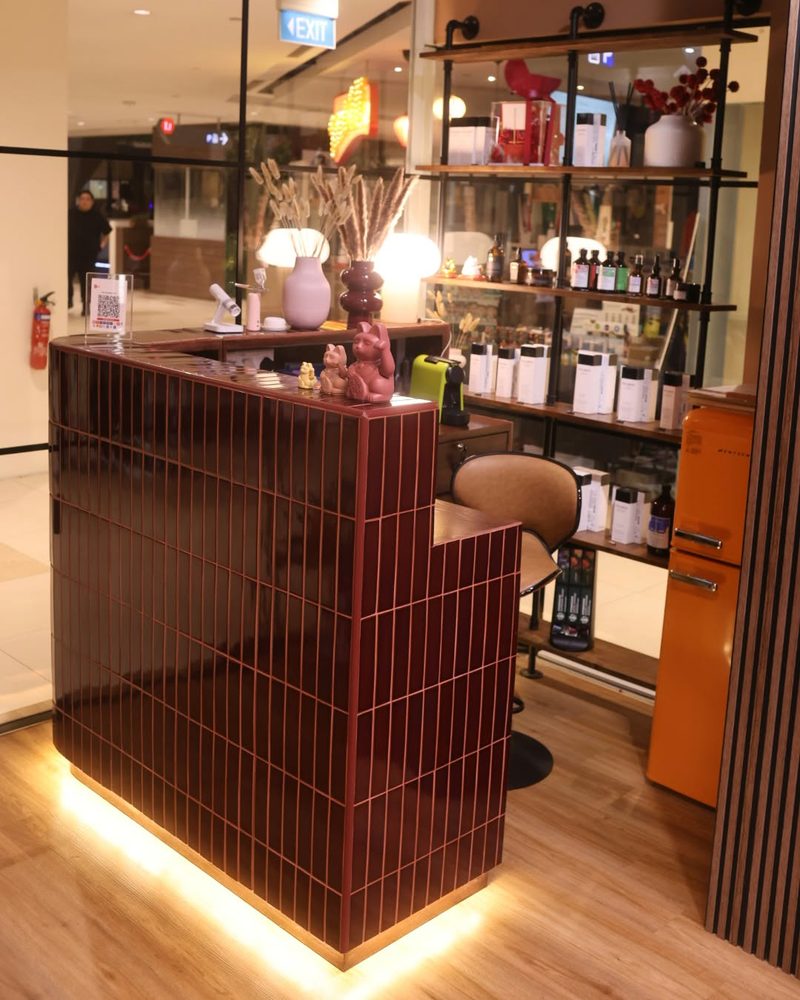 Maroon-tiled reception counter with a warm glow at its base at One Degree Edit, Havelock 2